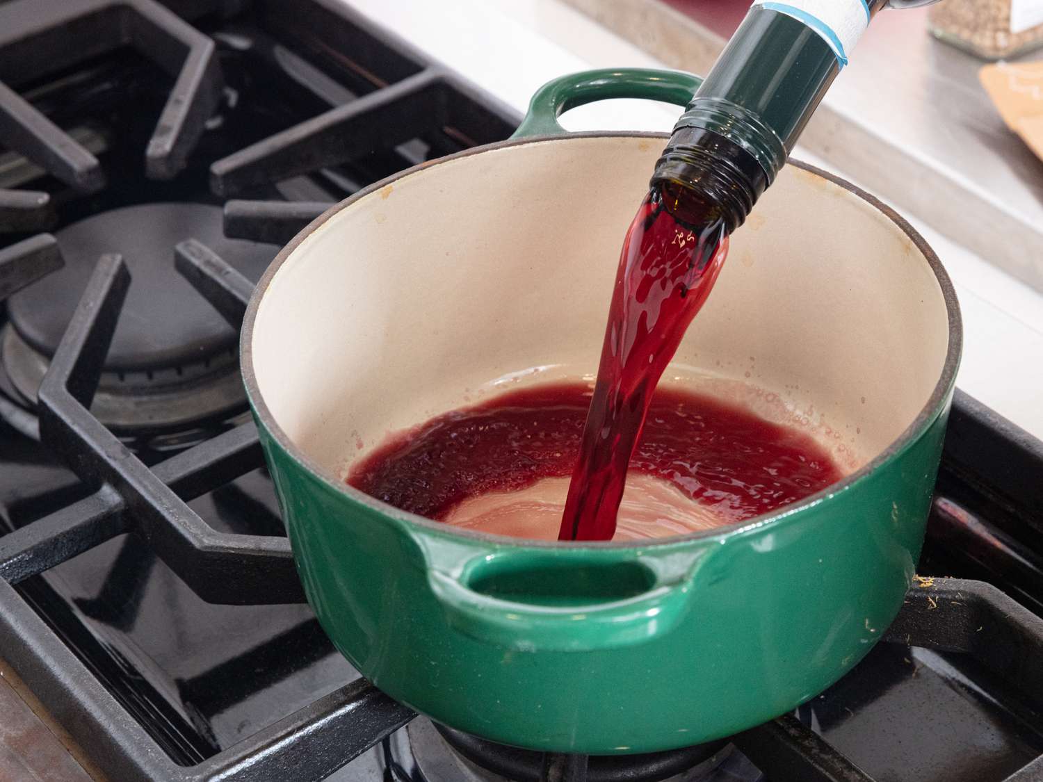 pouring red wine into dutch oven on stove top