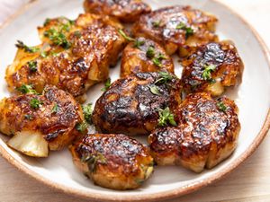 Smashed sunchokes with thyme-butter on a plate.