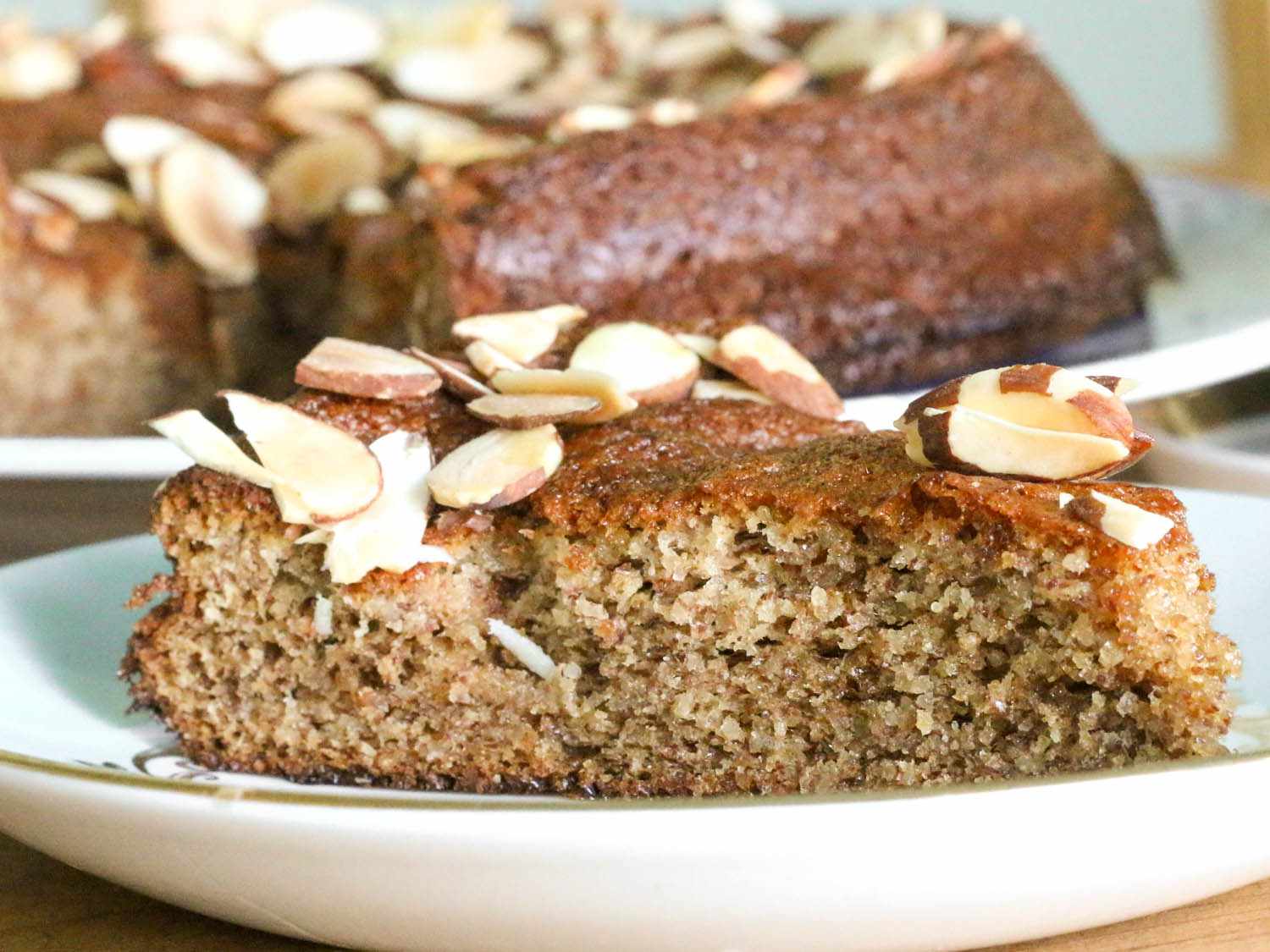 A side shot of a slice of almond cake, showing off the moist crumb of the cake.