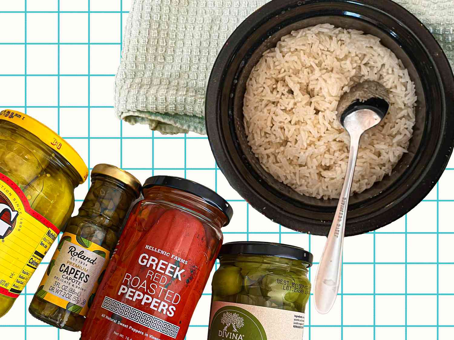 basmati rice in a bowl with a silver spoon accompanied by jars of brined vegetables