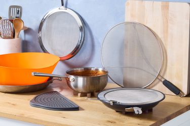 a variety of splatter screens with a pot full of tomato sauce