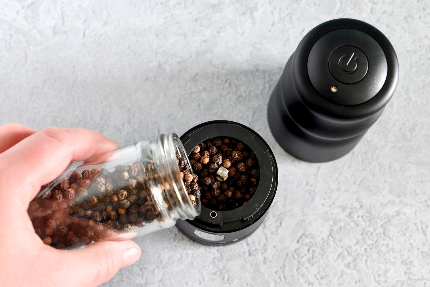 a person filling a pepper mill