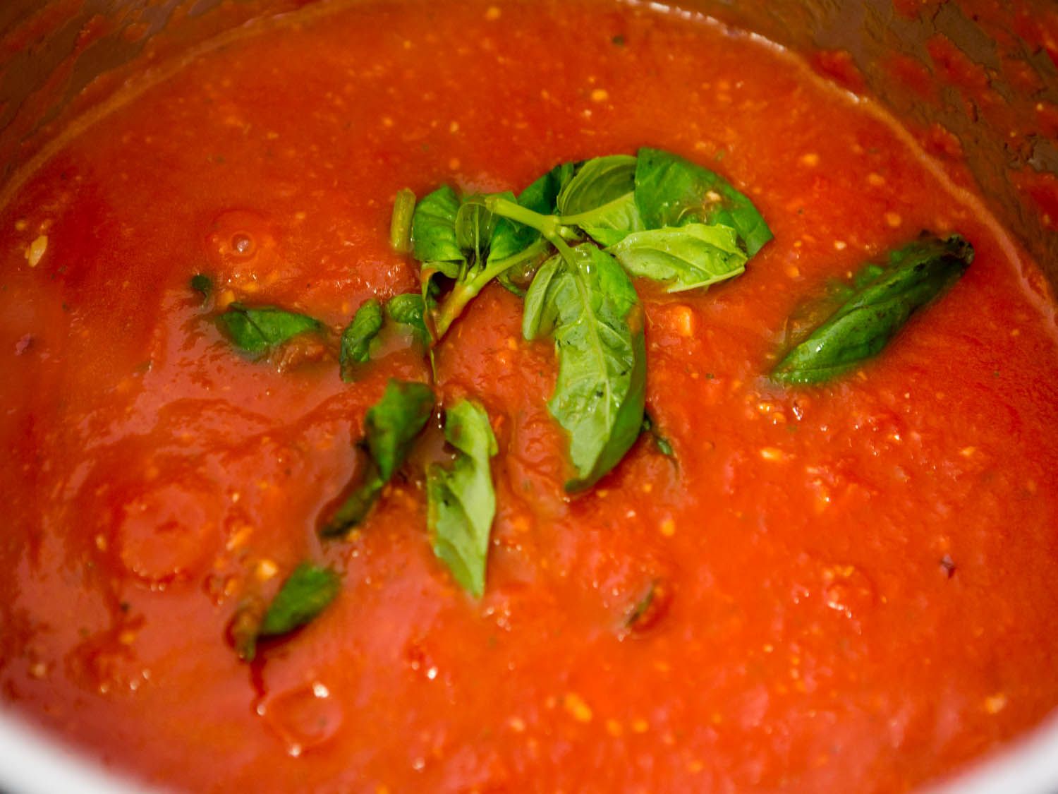 Basil added to a pot of quick Italian-American red sauce.