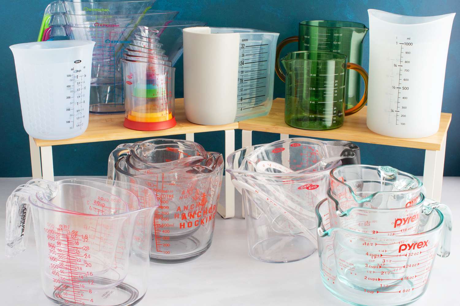 Numerous liquid measuring cups on a marble countertop.