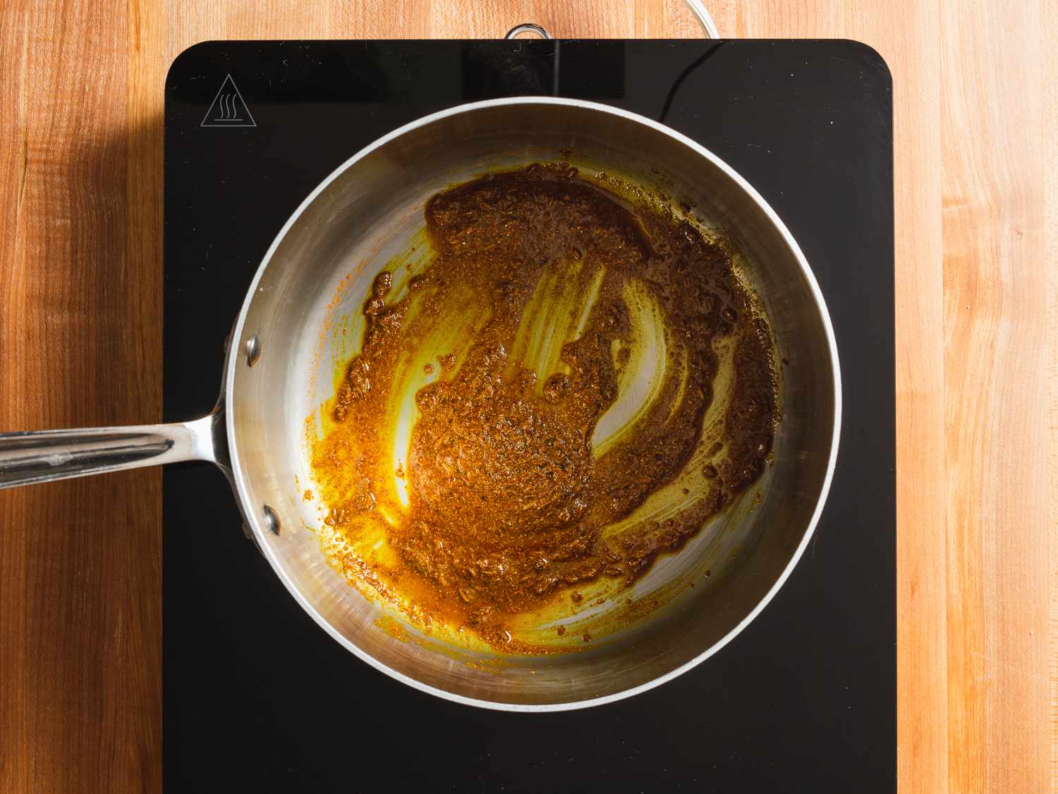 Spices for potato samosa filling being bloomed in oil in a saucepan