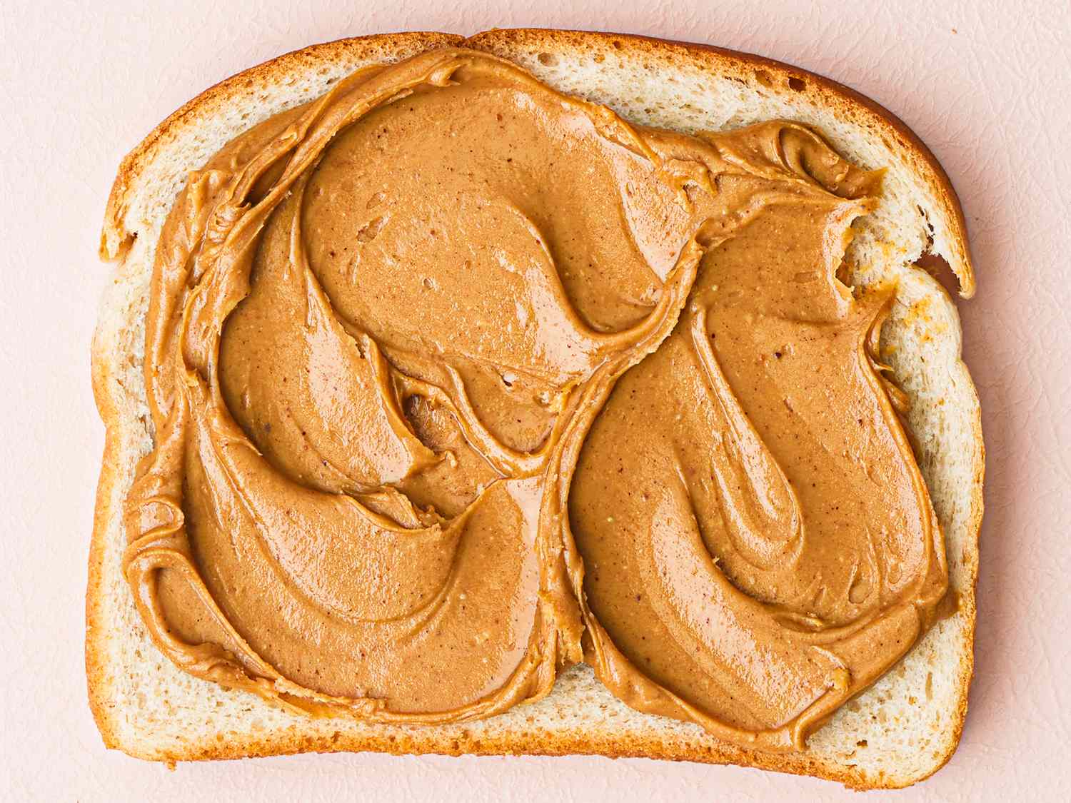 Slice of bread with peanut butter spread evenly