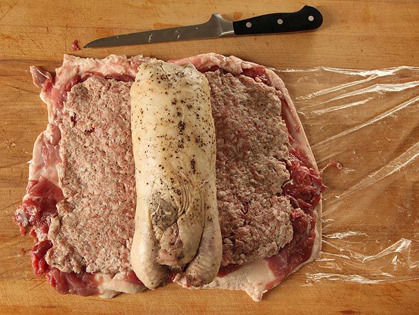 Par-cooked chicken centered on top of sausage layered over deboned duck