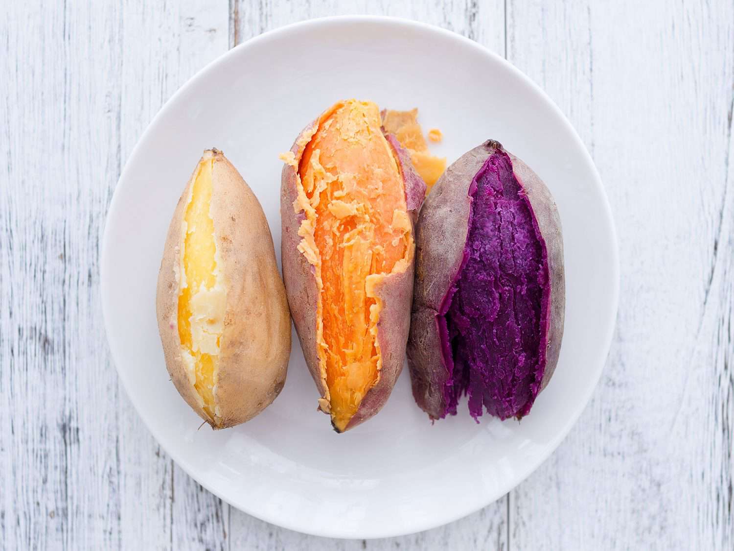 Three varieties of sweet potato, cooked, on a plate.