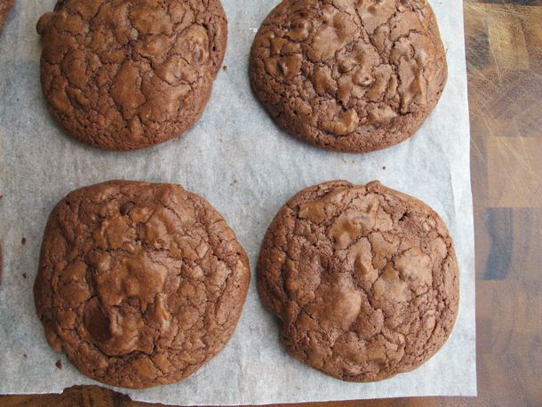 Overhead view of a chocolate chip brownie cookies, arranged on a sheet of parchment paper.