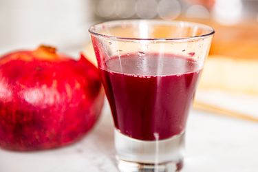 Side view of a glass of pomegranate juice 