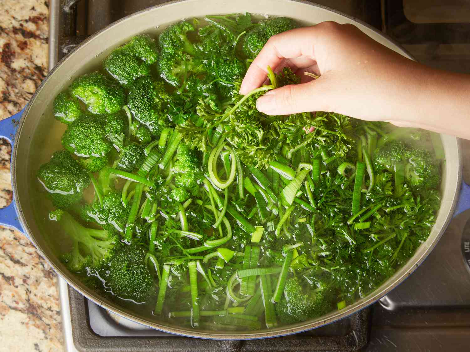 Adding leek tops and parsley to dutch oven