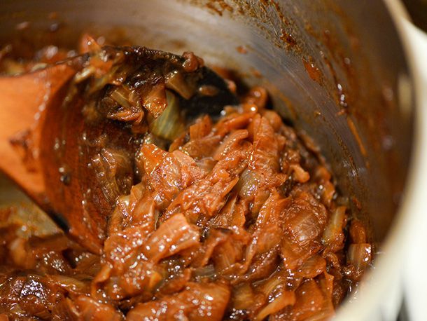 Closeup of caramelized onions being stirred in a saucepan.