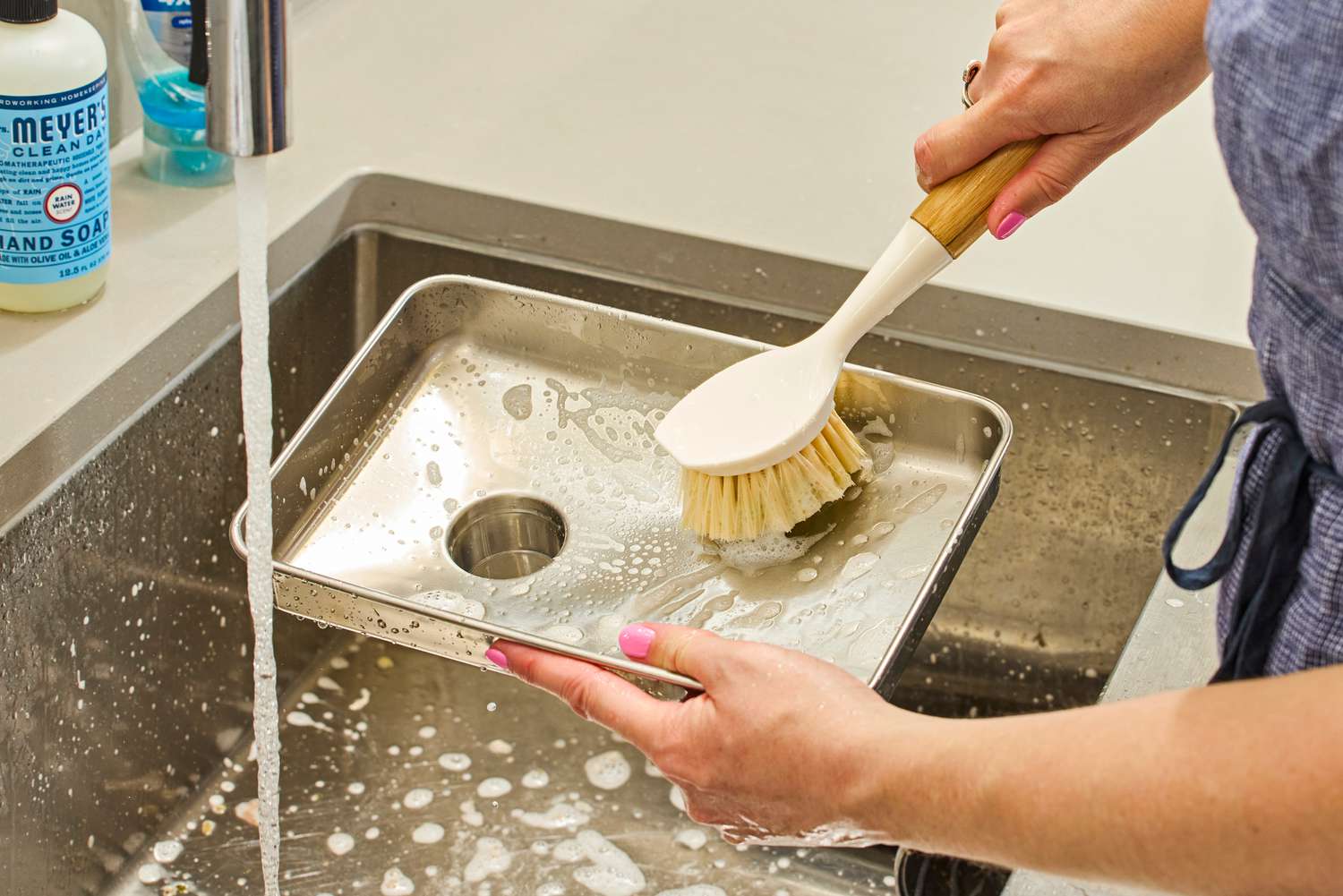 Person cleaning food tray of Weston #8 Electric Meat Grinder with brush