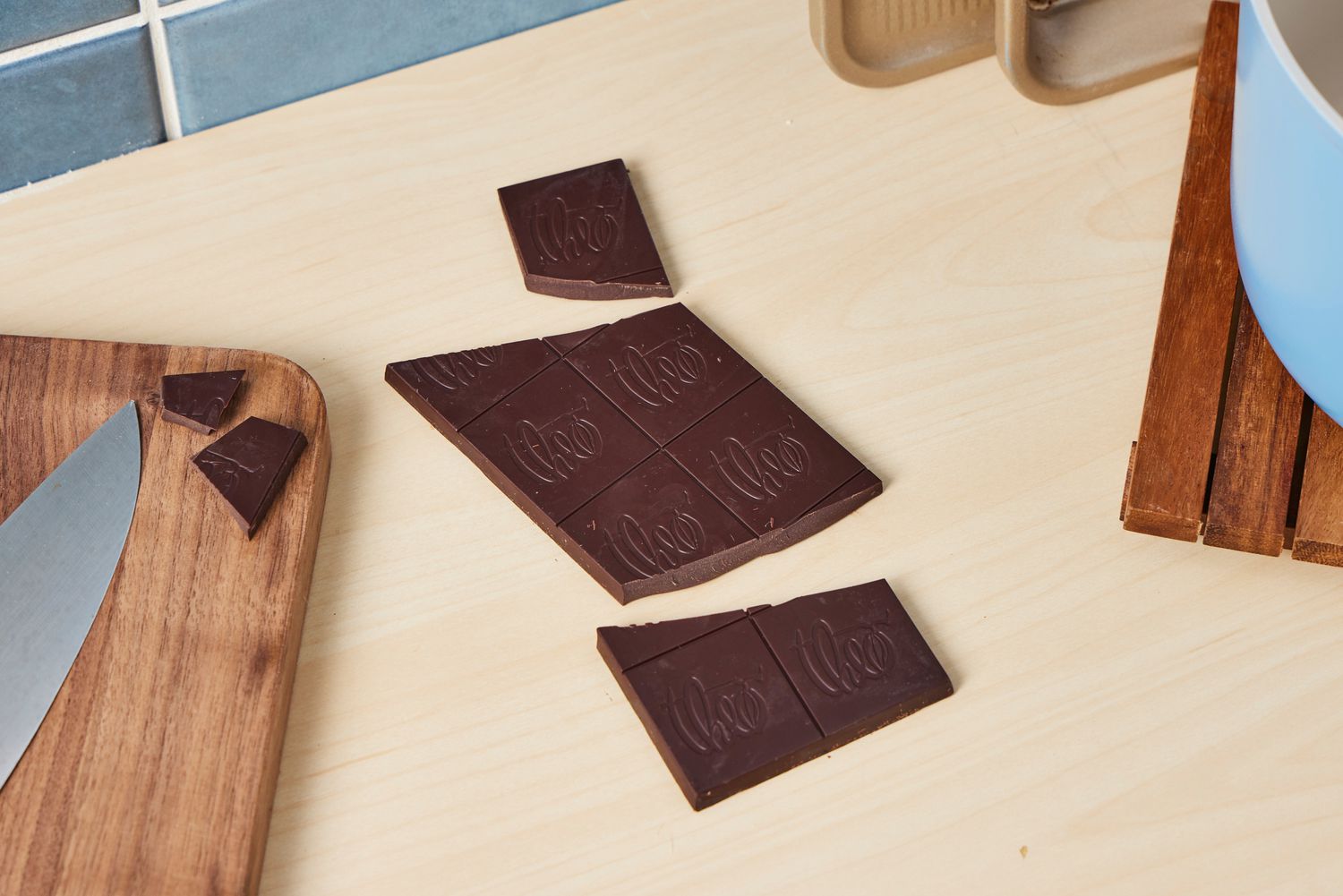 Unwrapped Theo's dark chocolate on a kitchen countertop.