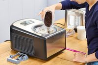 A person adding toppings to the Cuisinart Compressor Ice Cream and Gelato Maker