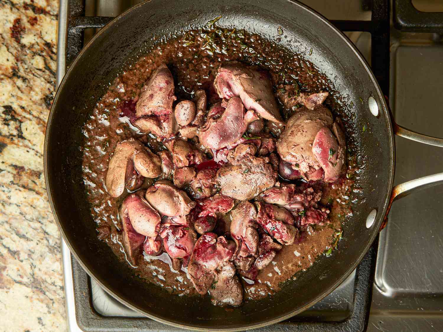 Overhead view of sautÃ©ing chicken livers in pan