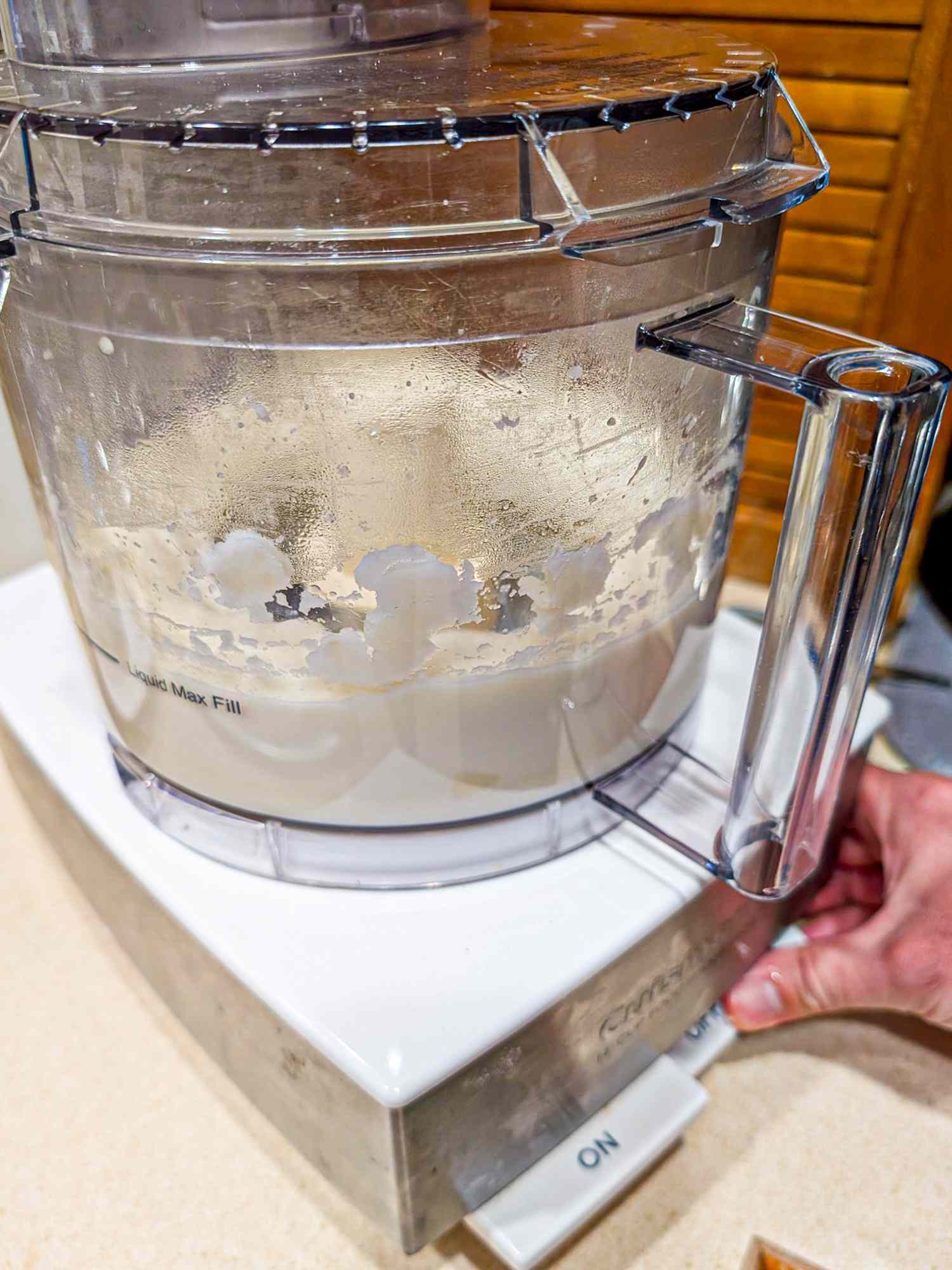 A blender mixing mashed potato with a visible hand operating it