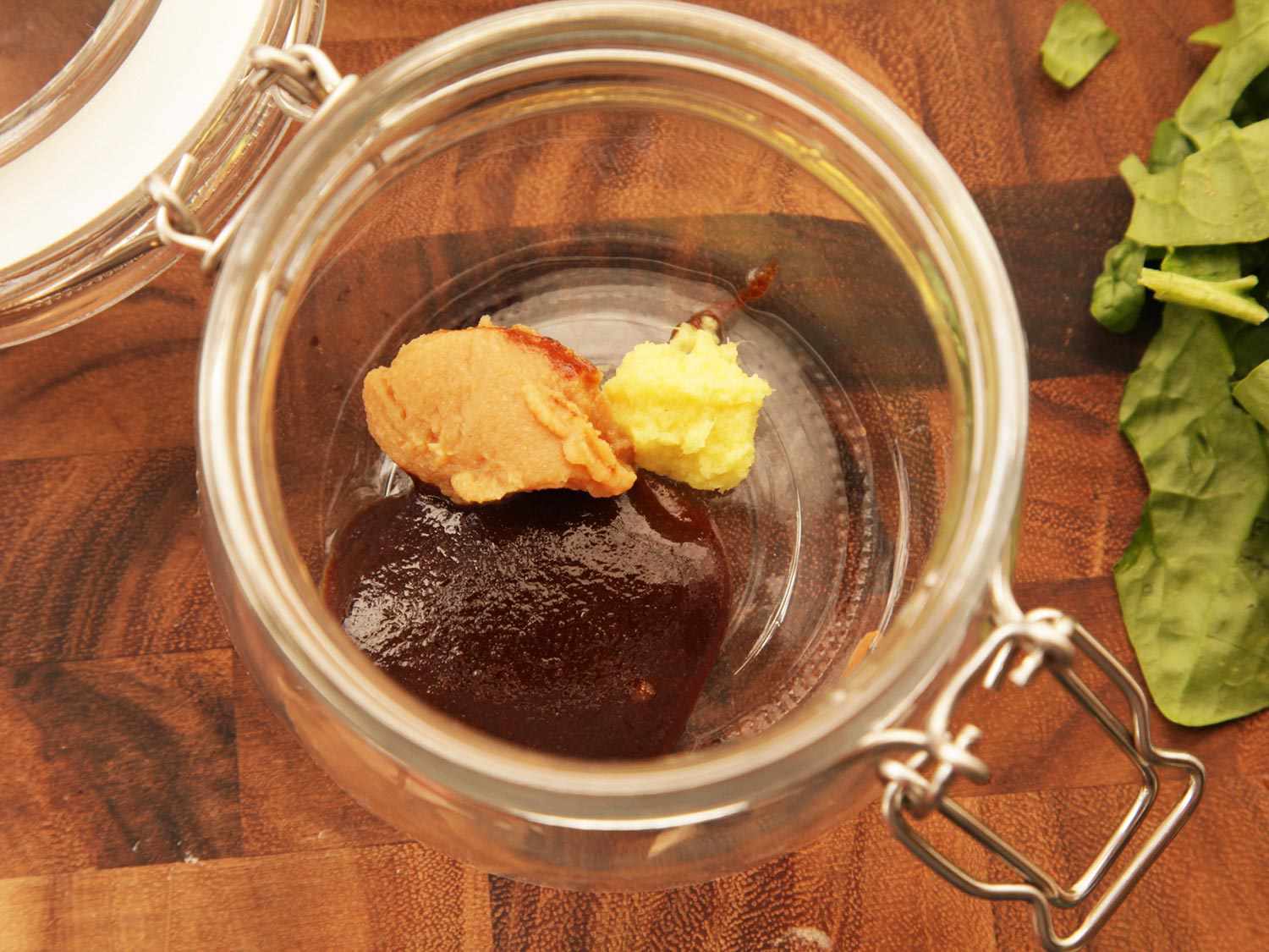 A flip top jar containing broth base and several other aromatic pastes.