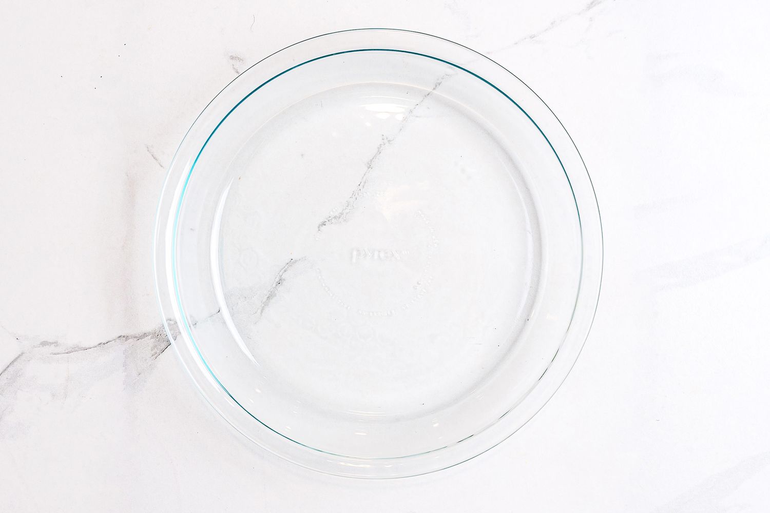 A Pyrex 9-Inch Glass Pie Plate on a white marble countertop