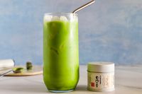 A glass of Ippodo Tea Ummon Matcha next to the container