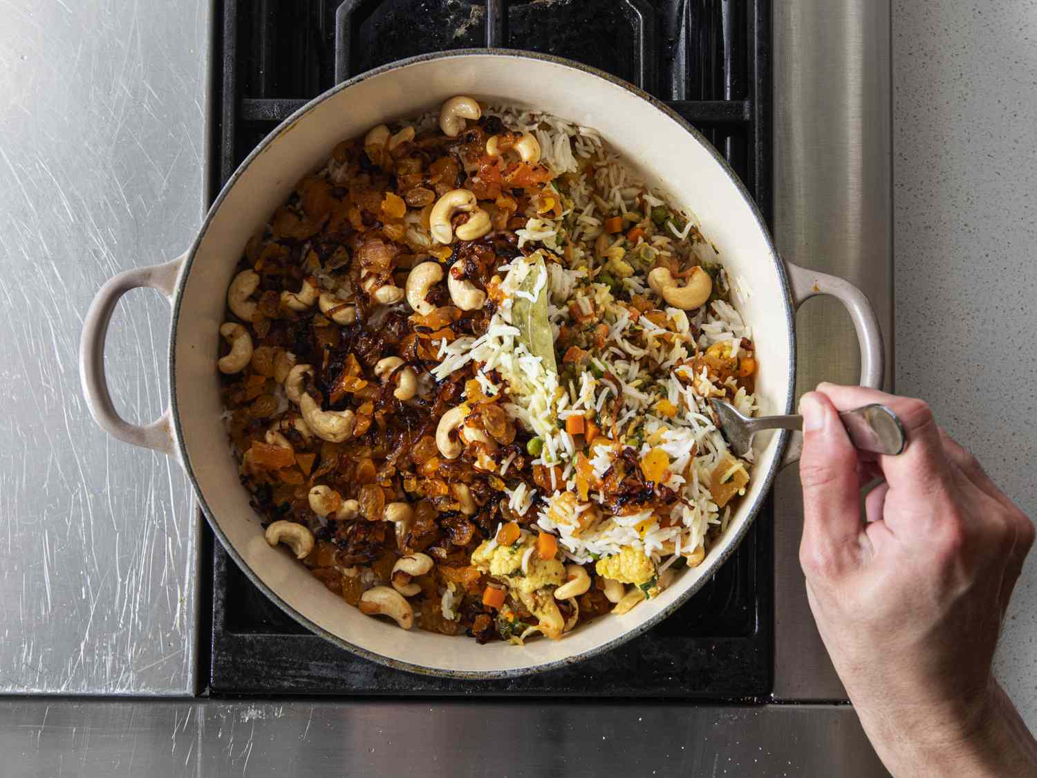 Biryani being fluffed with a fork