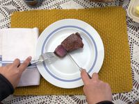 a person using the grand maitre steak knives to cut a piece of steak