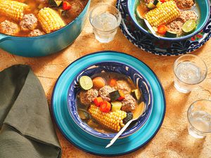 Overhead view of Mexican Albondigas in a bowl with pot and water