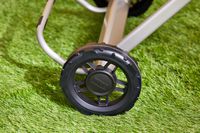 A closeup of the Weber Traveler Portable Gas Grill wheel on grass
