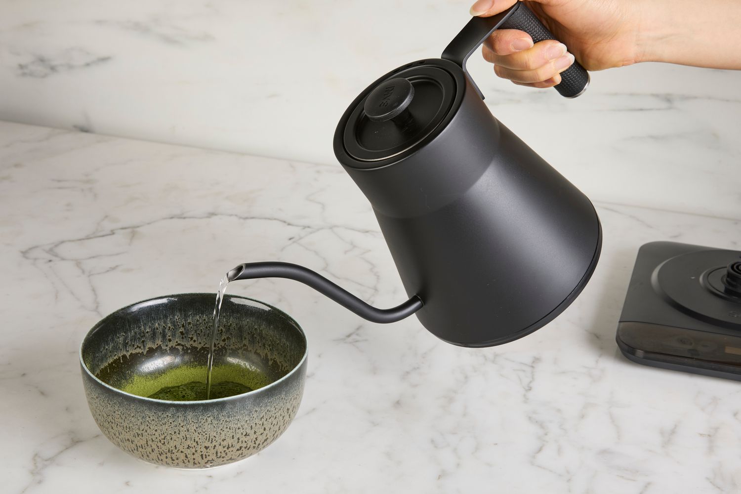 Person pouring water from Saki Baristan Electric Gooseneck Kettle