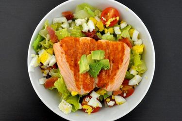 Overhead view of a California Cobb salad made with salmon and goat cheese.