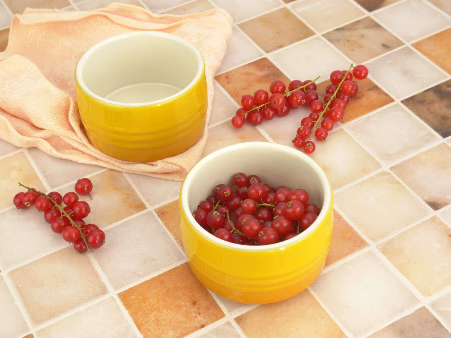 le creuset ramekins on marble tile surface with currants