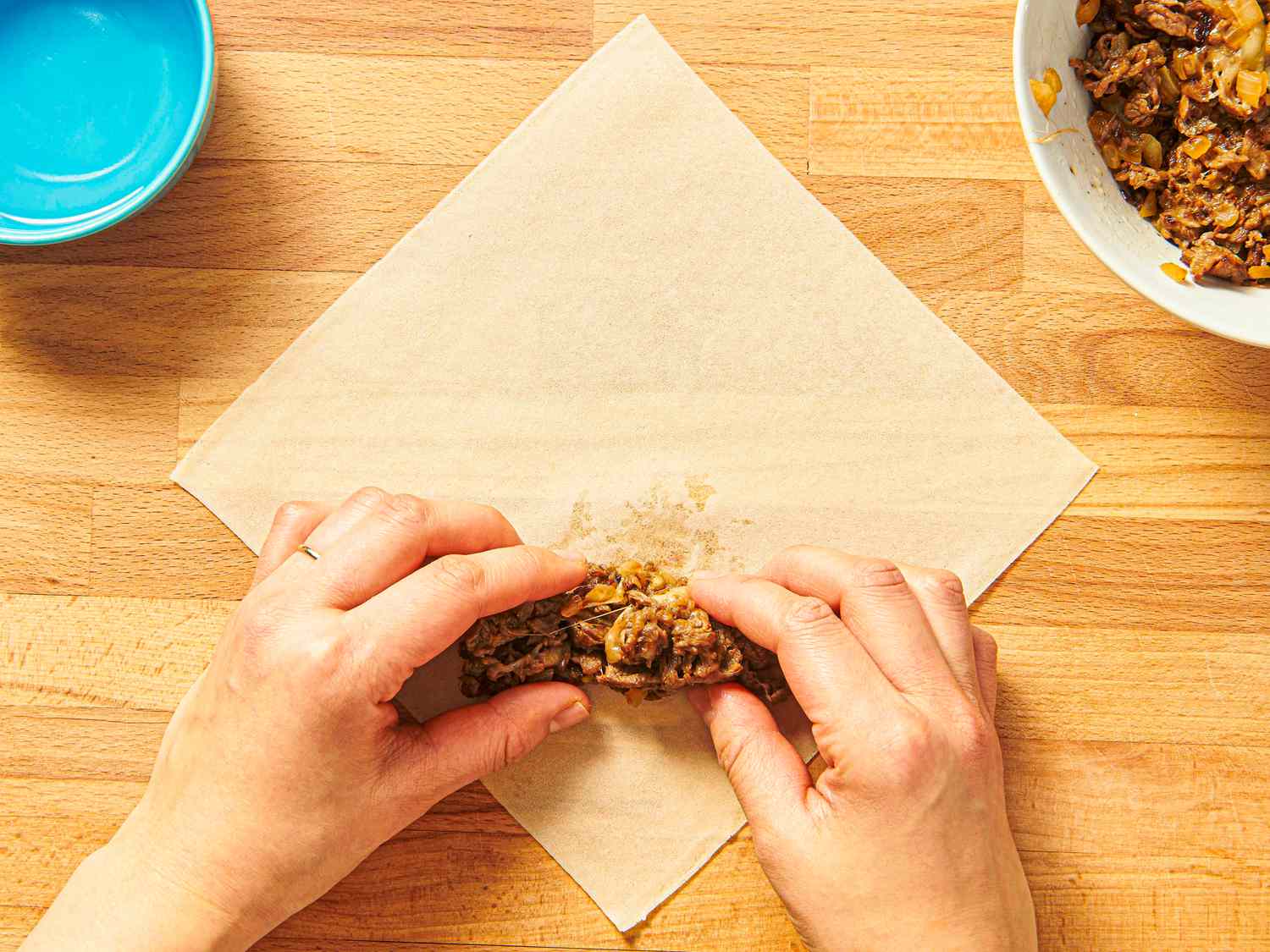 Overhead view of adding meat to eggroll wrapper