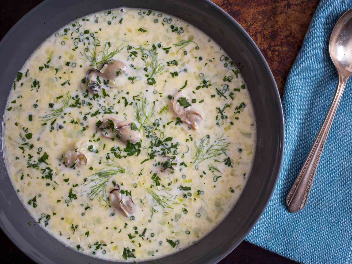 Overhead of a bowl of classic oyster stew with fennel next to a spoon.