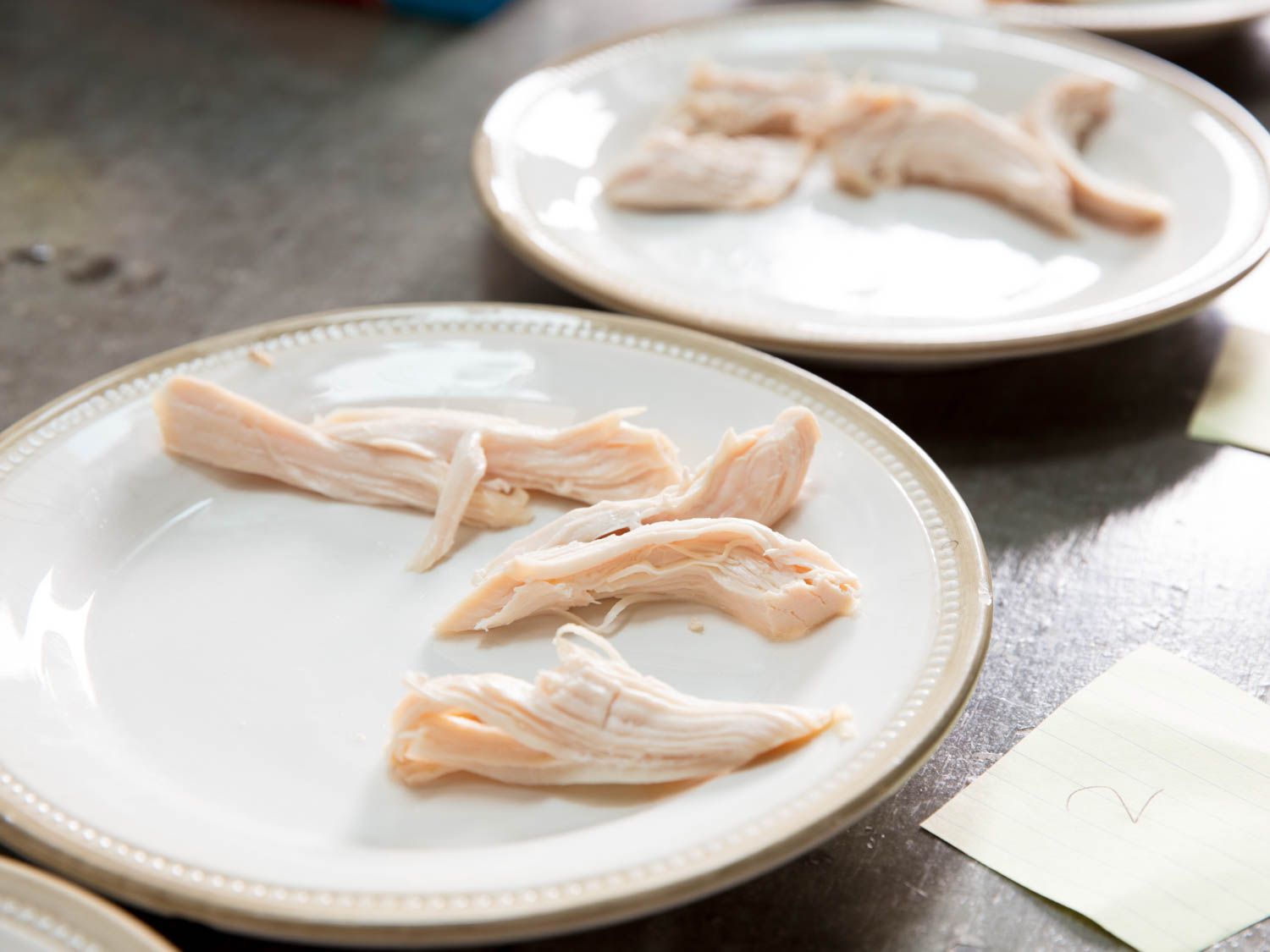 Large shreds of chicken are served on numbered plates for taste testing.