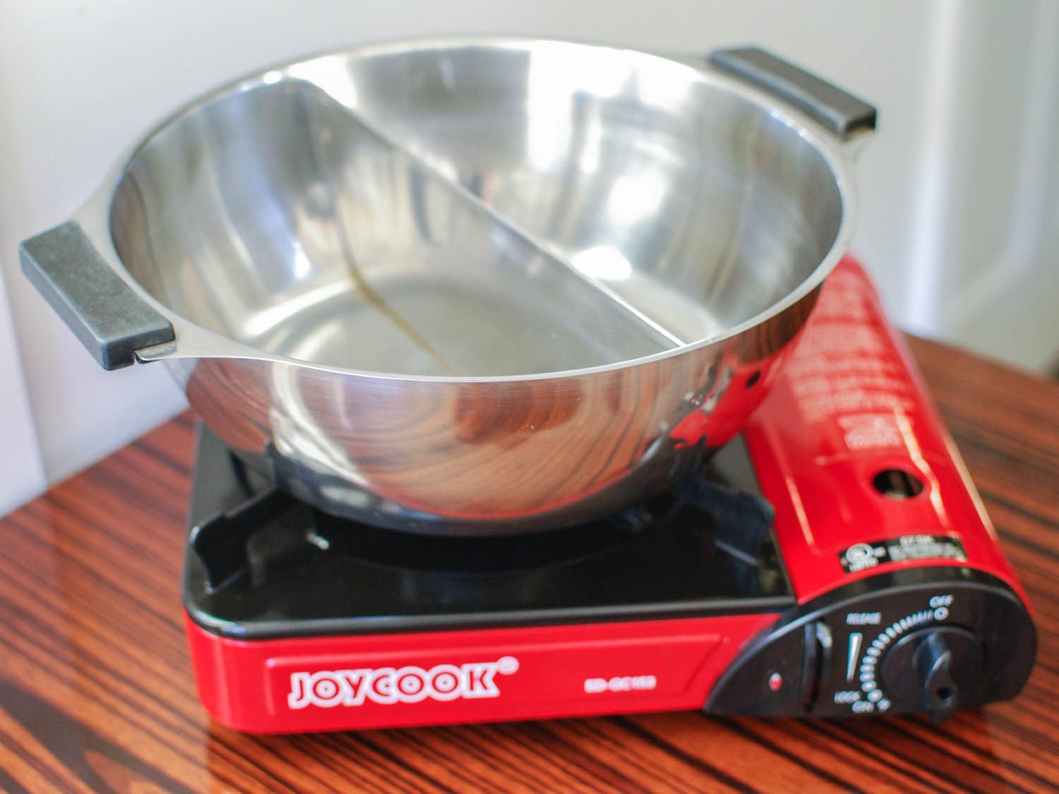 A hot pot with Divider on a portable butane burner for making Chinese hot pot.