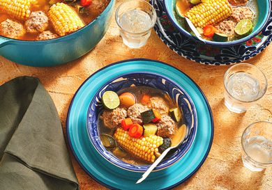Overhead view of Mexican Albondigas in a bowl with pot and water