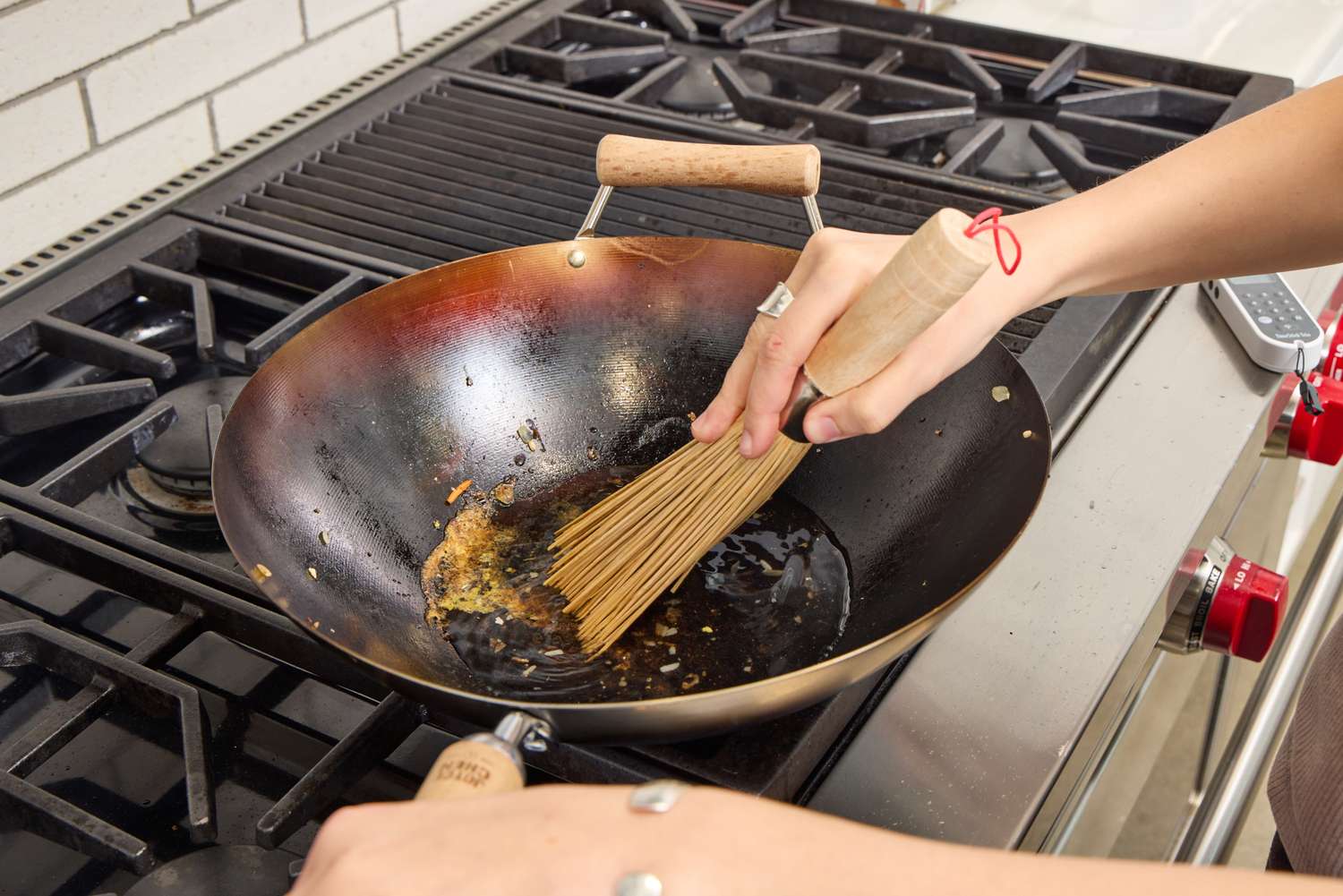 A person brushes the bottom of th eJoyce Chen Carbon Steel Wok with oil