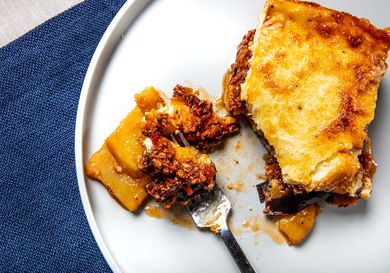 Overhead view of a fork of moussaka on a plate