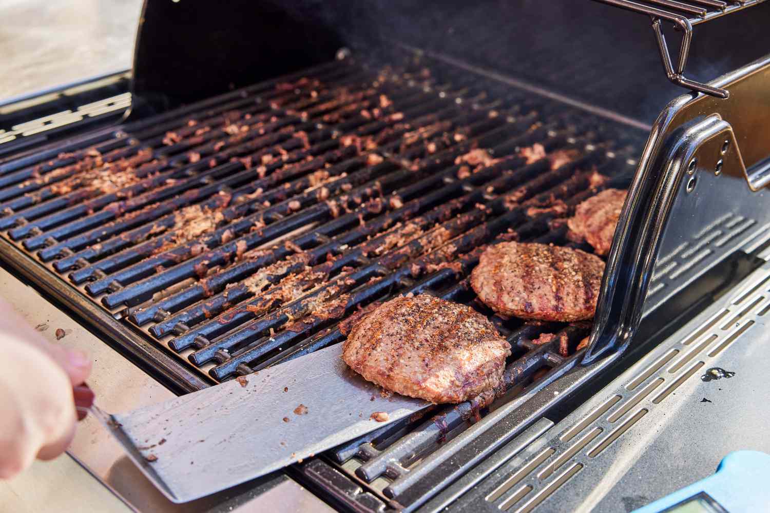 Spatula removing a burger from the Char-Broil Signature Series Amplifire 2-Burner Gas Grill