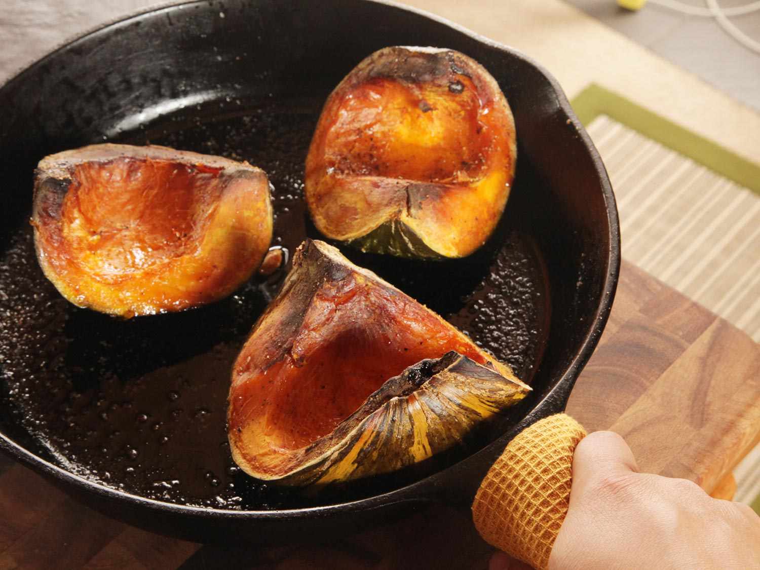 Roasted kabocha quarters in a cast iron skillet.