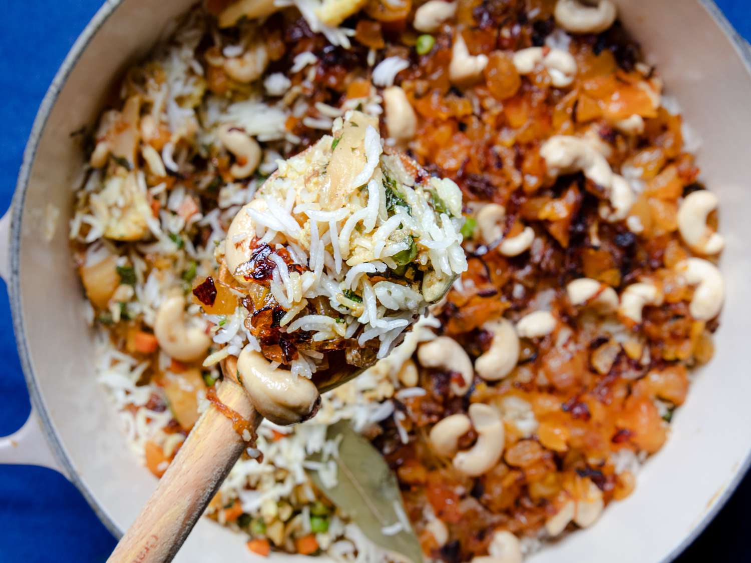 Close up image of a spoon wooden spoon full of biryani