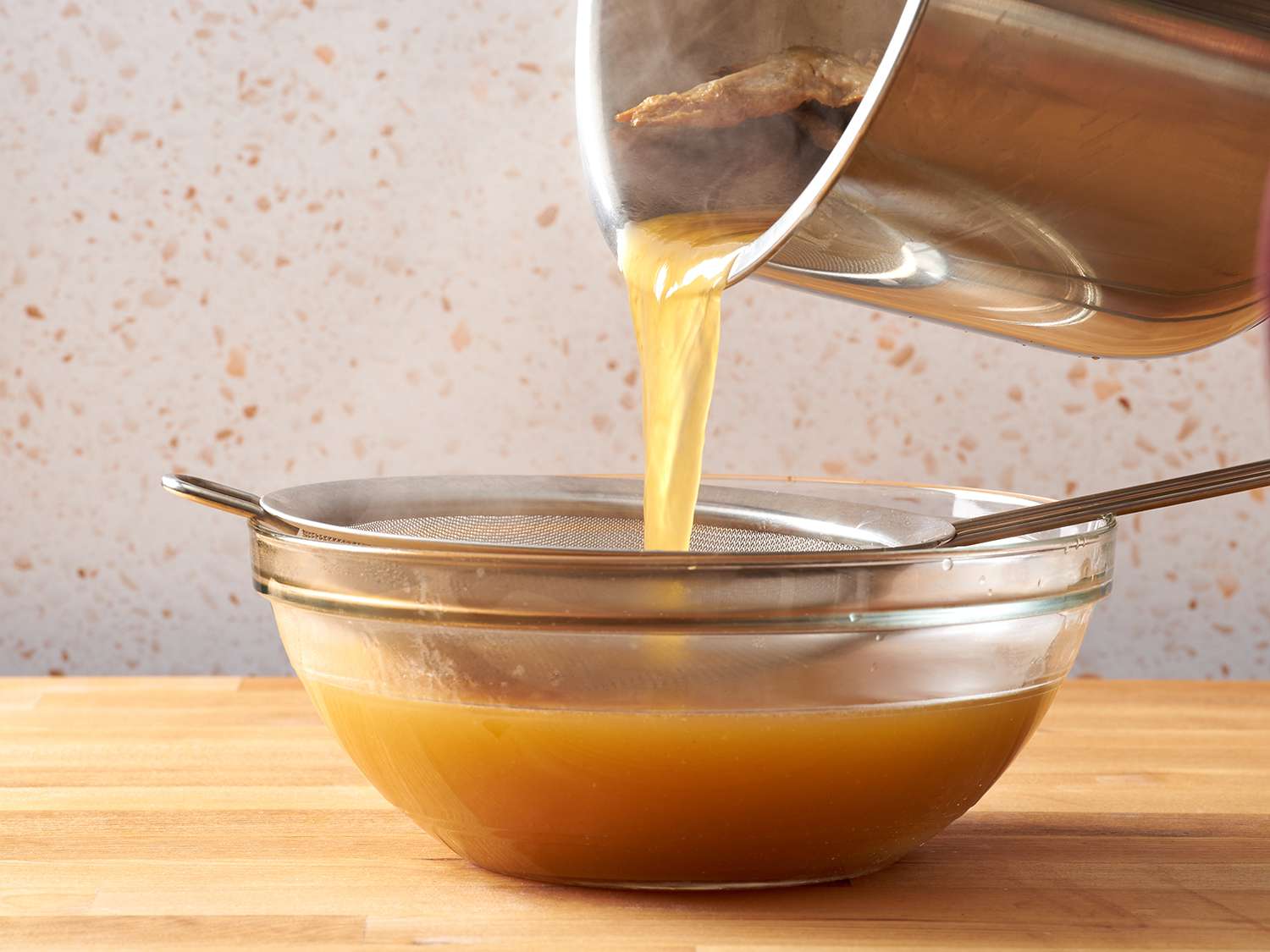 Straining chicken broth.