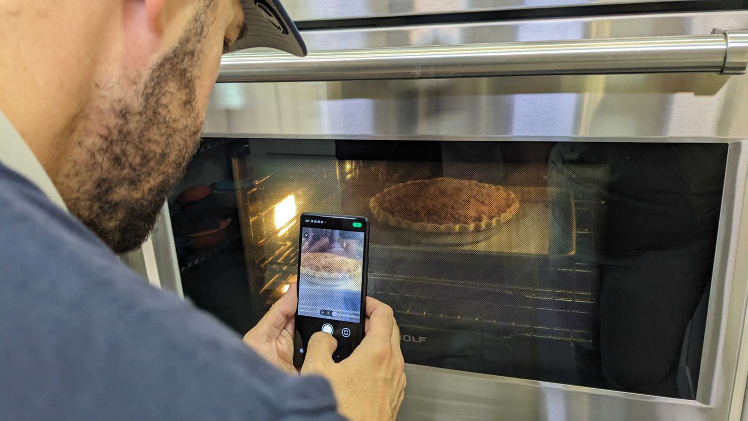 Daniel takes a picture of an apple pie in the oven.