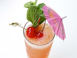 Zombie punch cocktail with cherries, mint, and an umbrella