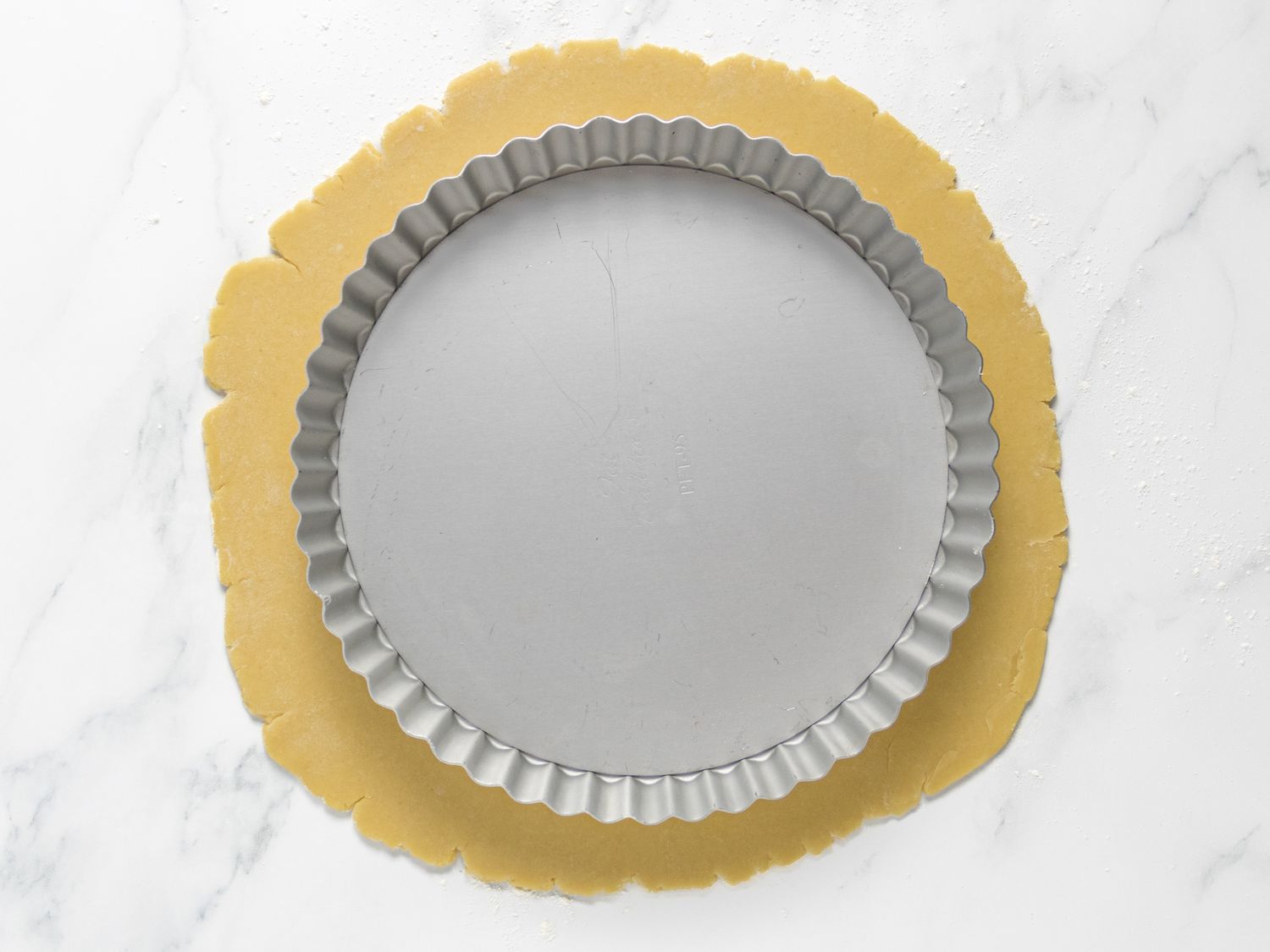 rolled out dough with a pie pan on top of it to ensure the dough extends wider than pan. 