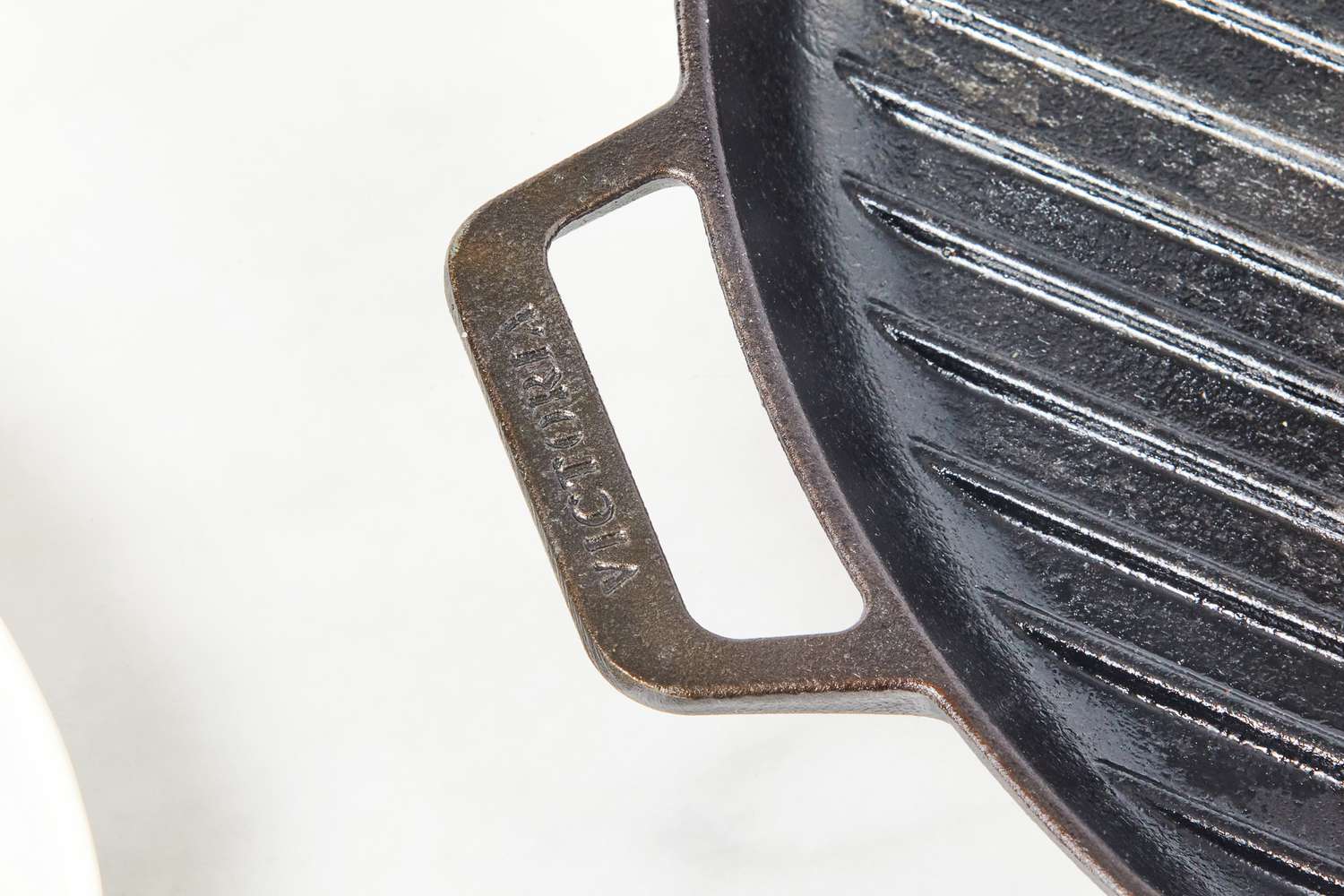 Close-up of the Victoria Cast Iron Square Grill Pan's handle.