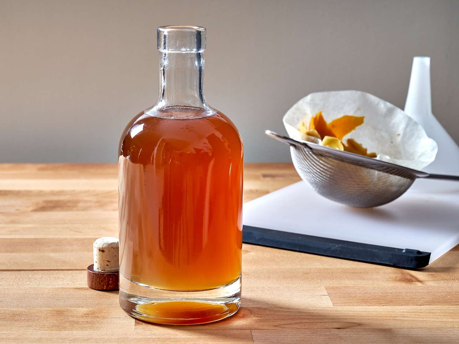 DIY ginger liqueur mixture strained into a bottle.