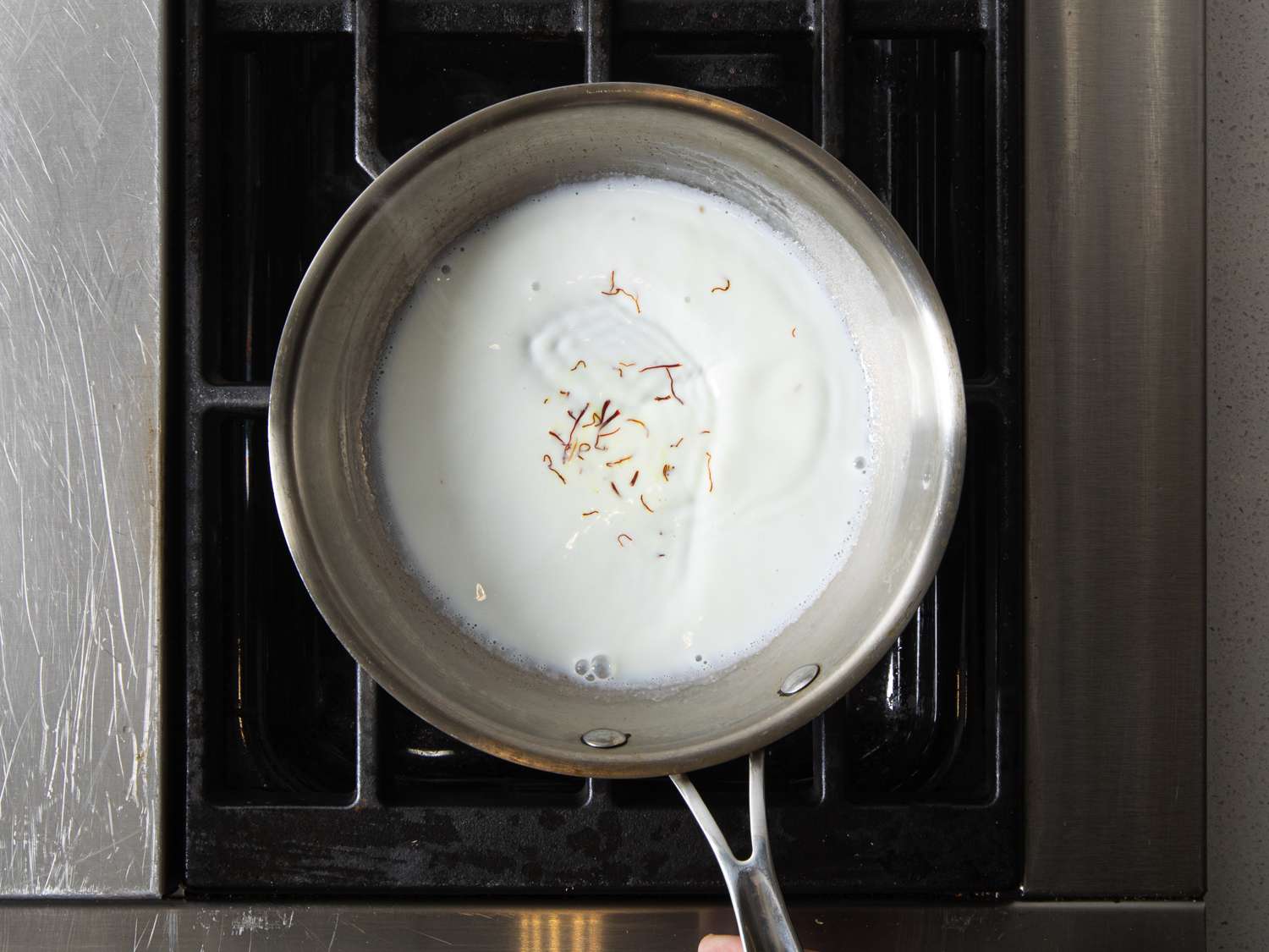 Overhead view of saffron infusing in milk