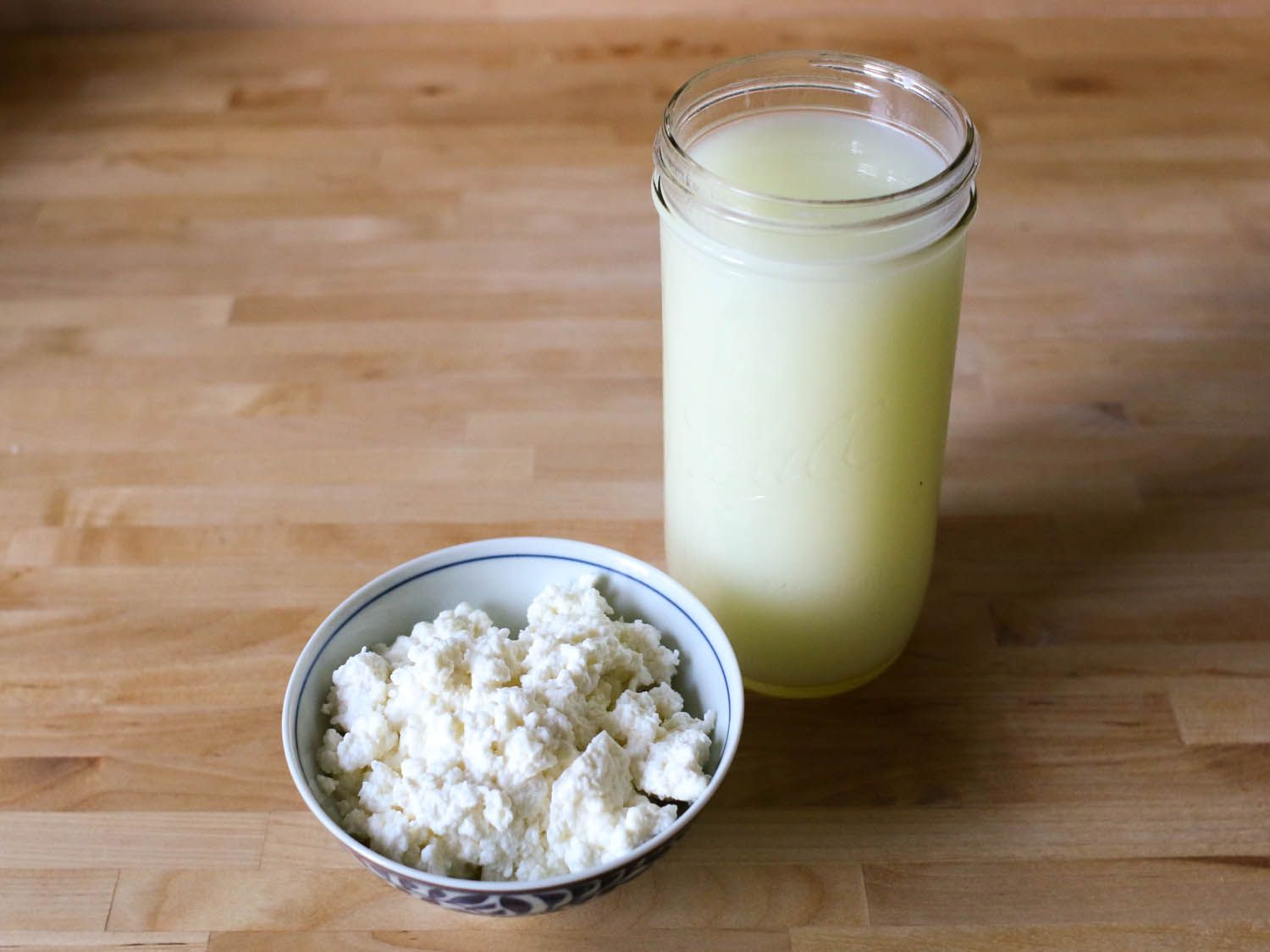 Curds and whey in a glass and a bowl. 