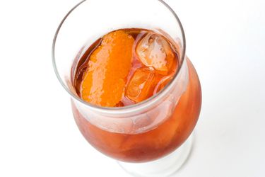 A Decolletage cocktail in a brandy snifter with orange peel. 